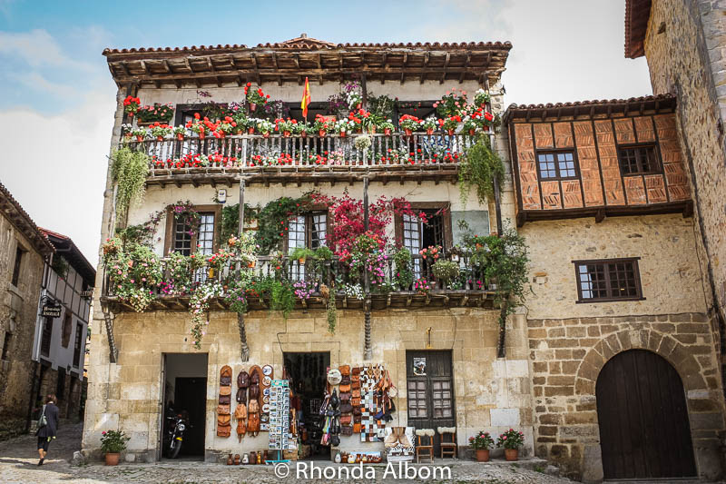 Santillana Del Mar, rustic stone buildings dripping with colourful balcony flowers.