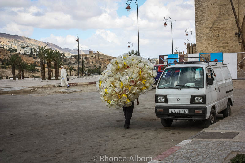 Man carrying 100s of empty water bottles.