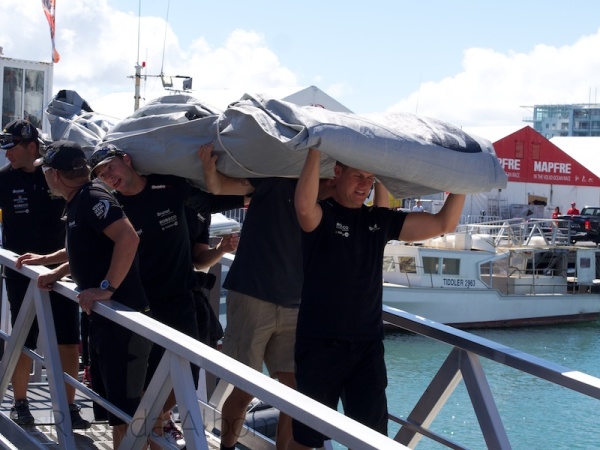 Carrying the sails down to the yacht.