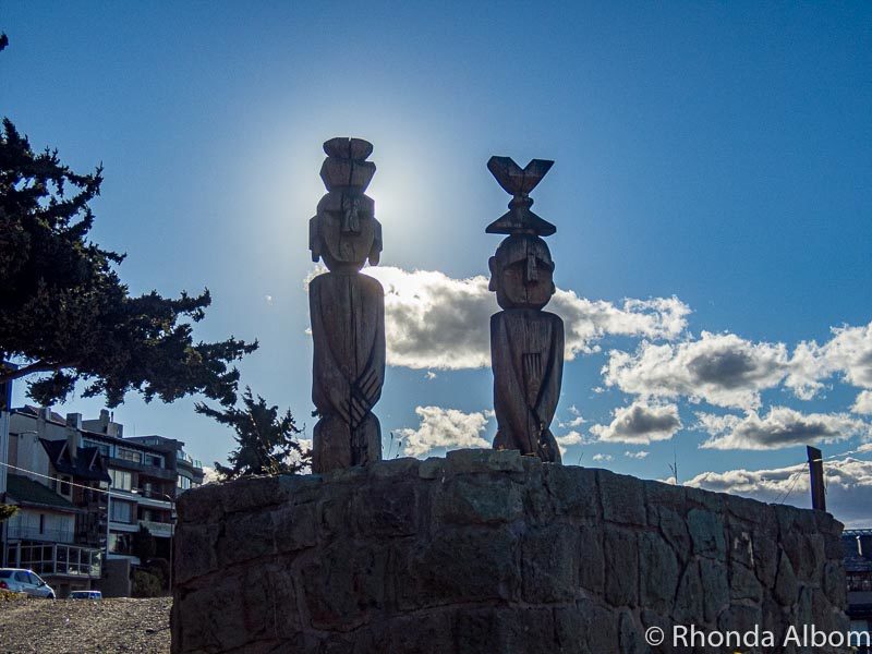 Native wood carvings of two people in front of the Nahuel Huapi Iglesia Cathedral in San Carlos de Bariloche, Argentina.