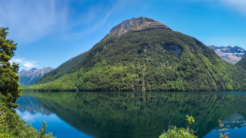 Lake Gunn Panorama with Reflections in water - scenic stopover on the road to Milford Sound in Fiordland National Park, New Zealand, South Island.