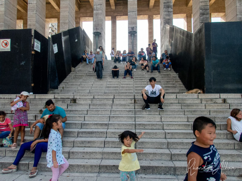 People hanging out on the steps facing the National Monument of the Flag in Rosario Argentina.