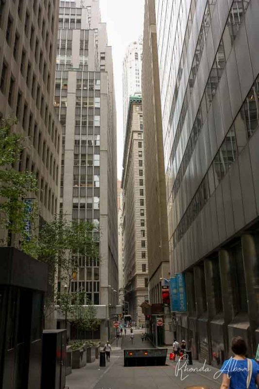 Tall building line the narrow Wall Street, one of the New York City highlights