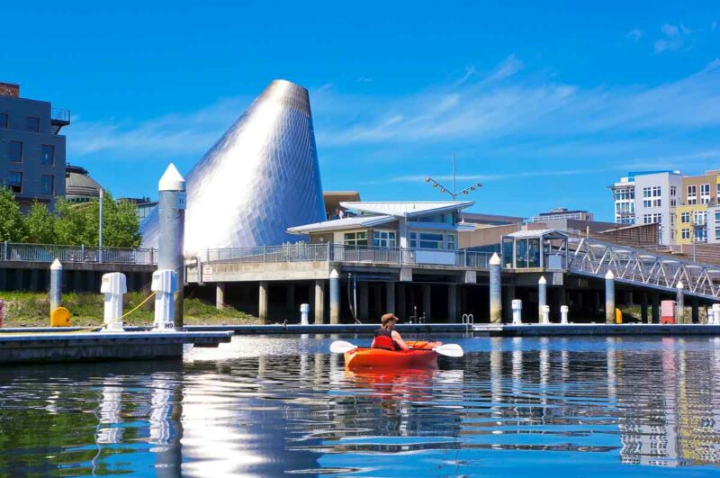 Tacoma downtown marina with Glass Museum Dome and kayaker in Puget Sound. It's one of the quick trips from Seattle.